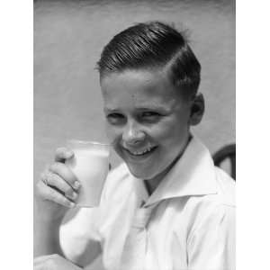  Smiling Eager Boy in White Shirt Holding Up a Glass of 