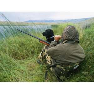  A Hunter Using a Goose Call by a Small Pond in Wyoming 