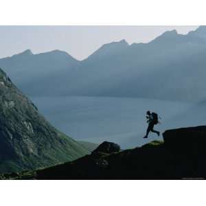 Man Runs Down a Hill Toward Base Camp Near Tasermiut Fjord Premium 